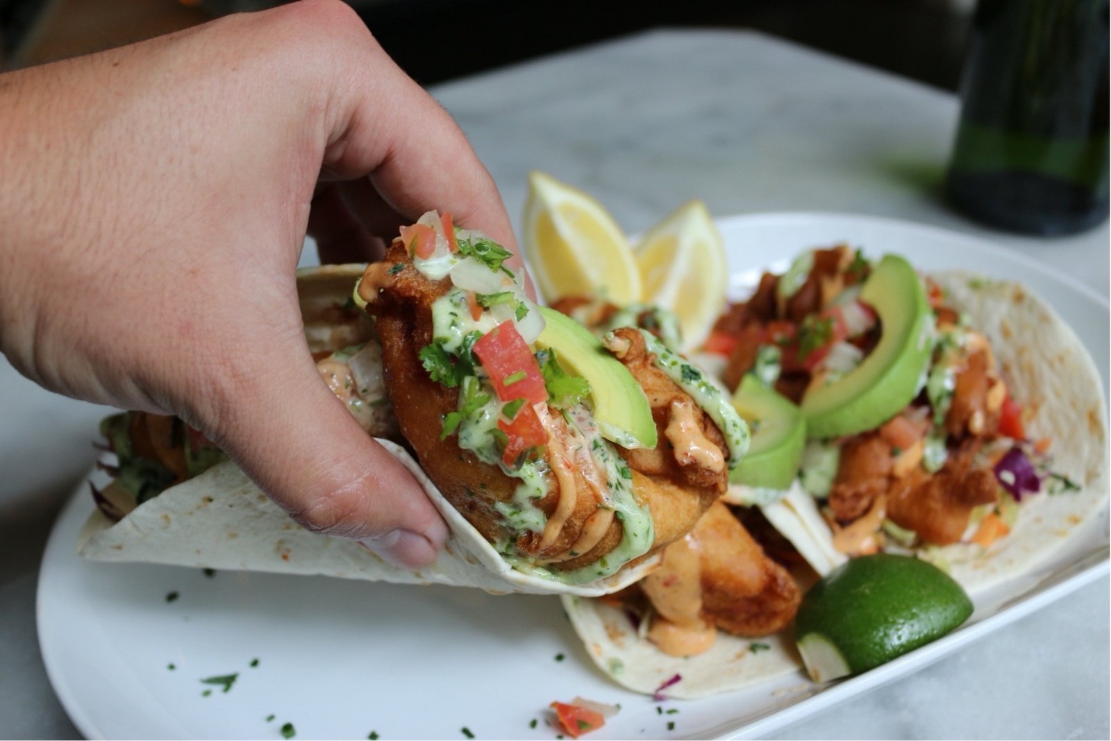 a guest holding an ahi taco in la pergola seattle